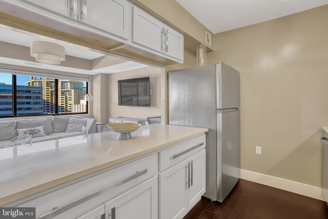 kitchen featuring dark wood-type flooring, stainless steel fridge, and white cabinets