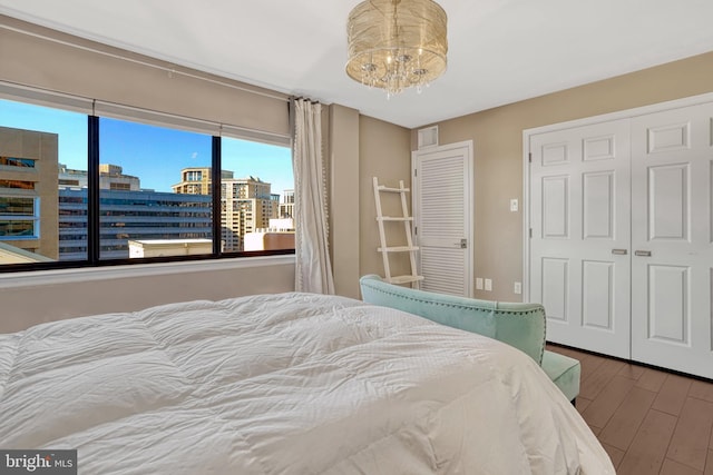 bedroom with hardwood / wood-style floors, a closet, and a chandelier