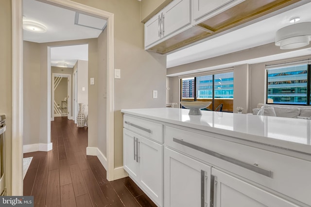 kitchen with dark hardwood / wood-style floors and white cabinets