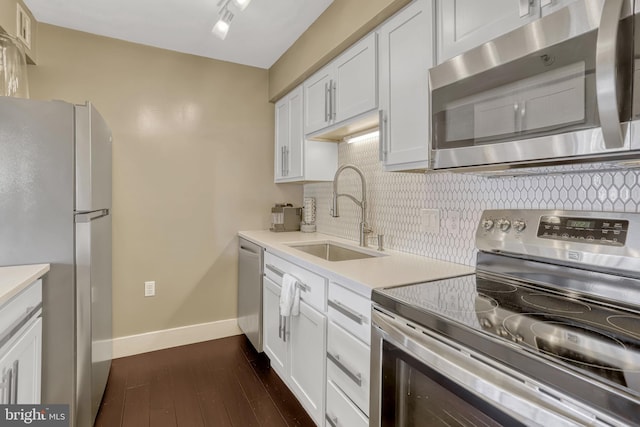 kitchen with sink, stainless steel appliances, dark hardwood / wood-style floors, white cabinets, and decorative backsplash