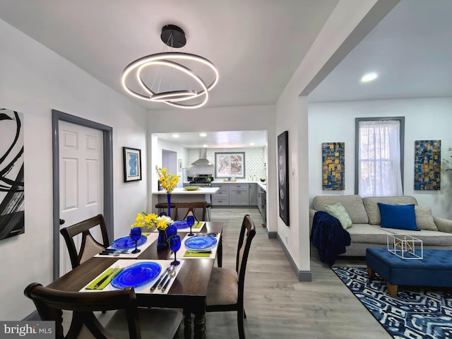 dining space with light hardwood / wood-style flooring and an inviting chandelier