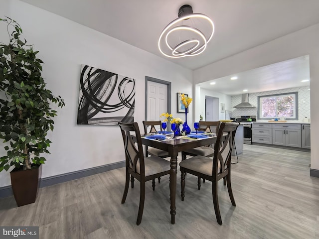 dining space with light wood-type flooring and an inviting chandelier