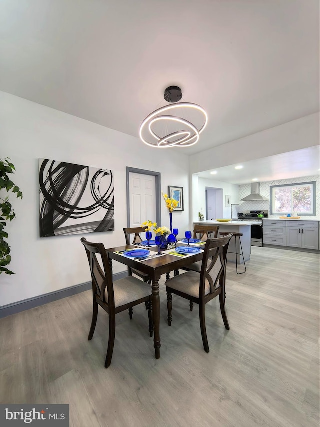 dining area featuring light hardwood / wood-style floors and a notable chandelier