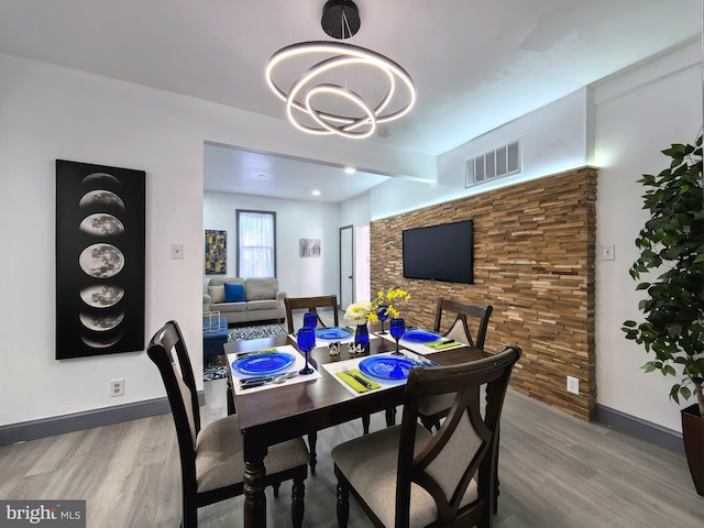 dining room with hardwood / wood-style floors and a chandelier