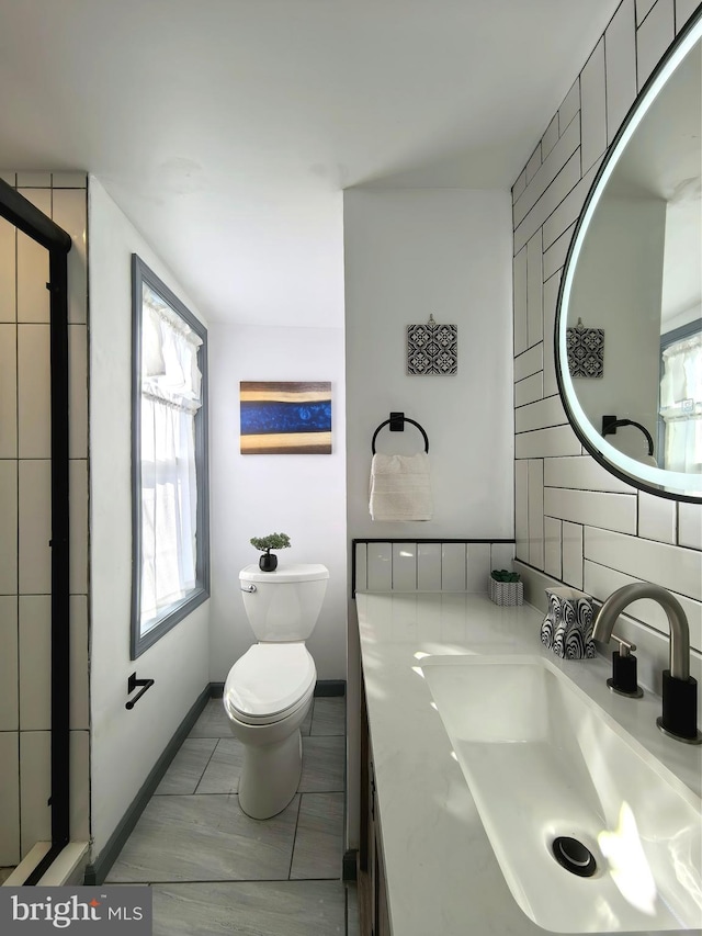 bathroom featuring tile patterned flooring, vanity, tasteful backsplash, and toilet