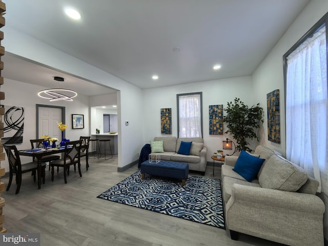 living room with hardwood / wood-style floors and a notable chandelier