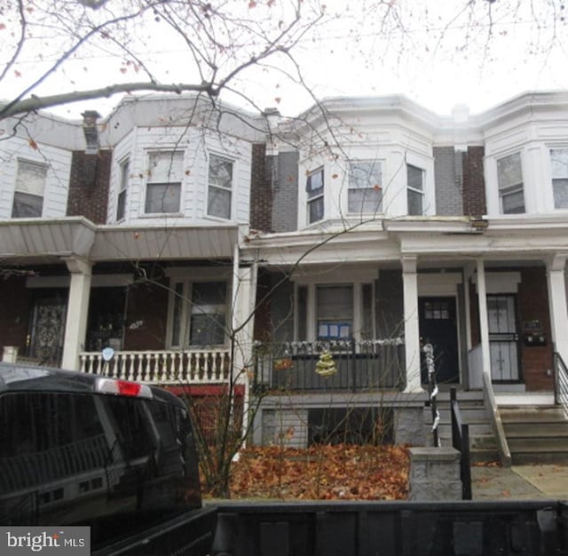 townhome / multi-family property featuring covered porch