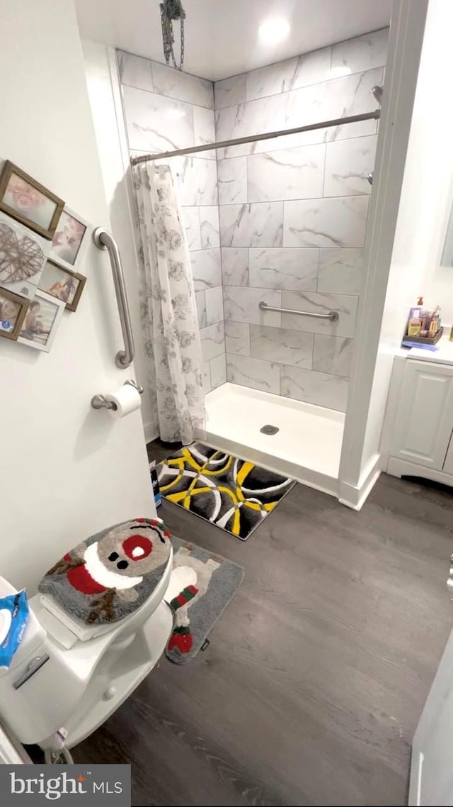 bathroom with hardwood / wood-style flooring, a shower with curtain, toilet, and vanity