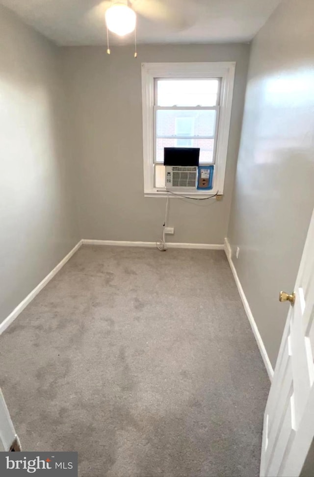 carpeted spare room featuring cooling unit and ceiling fan