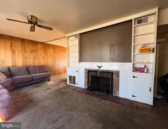 unfurnished living room featuring dark colored carpet, built in features, ceiling fan, and wood walls