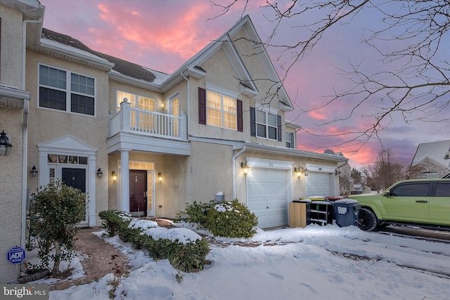 view of front of property featuring a balcony and a garage