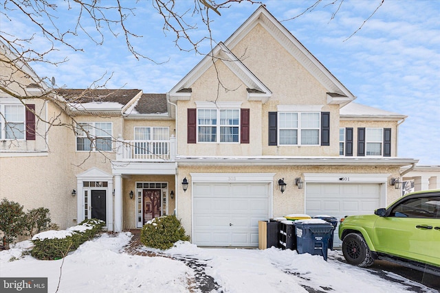 townhome / multi-family property featuring a balcony and a garage