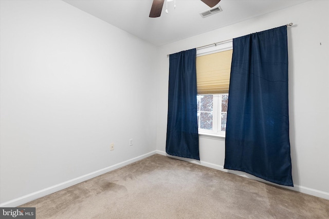 carpeted spare room with ceiling fan