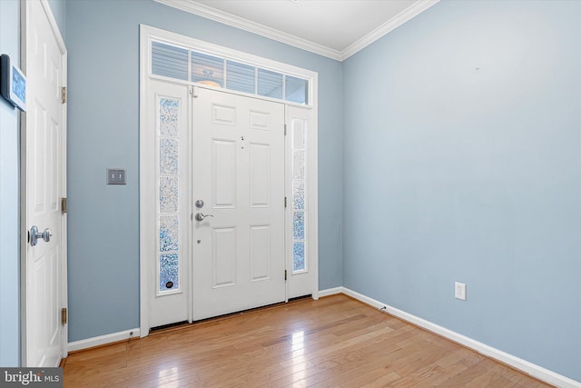 entrance foyer with ornamental molding and light hardwood / wood-style flooring