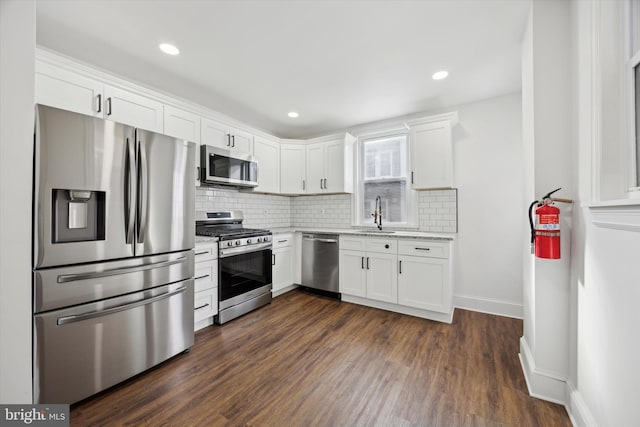 kitchen with dark hardwood / wood-style flooring, sink, white cabinets, and appliances with stainless steel finishes