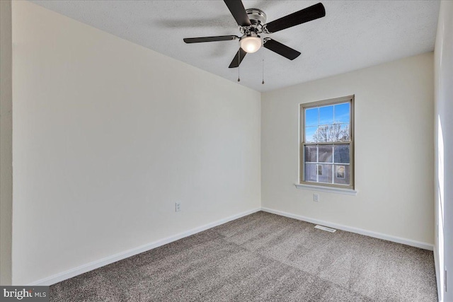 carpeted spare room featuring ceiling fan and a textured ceiling