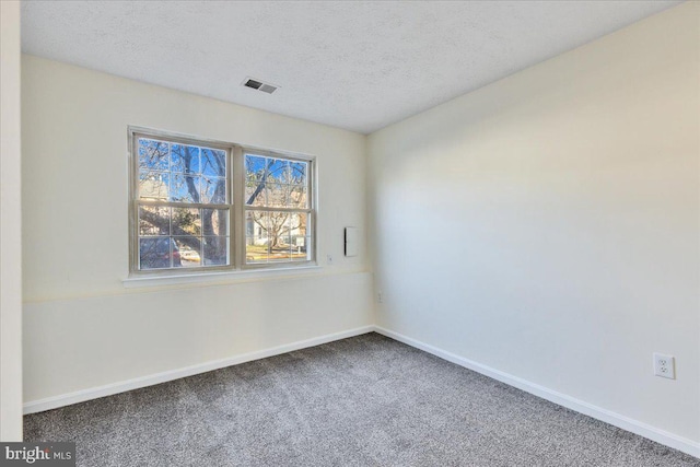 carpeted spare room with a textured ceiling