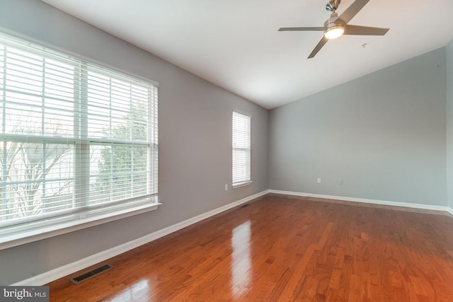 unfurnished room with ceiling fan, a wealth of natural light, and wood-type flooring