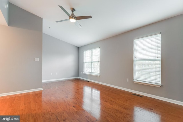 empty room featuring vaulted ceiling, hardwood / wood-style floors, and ceiling fan