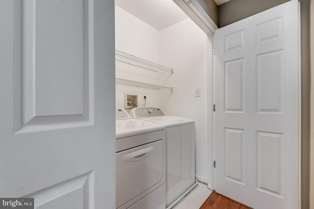 laundry area featuring washer and dryer and light hardwood / wood-style floors