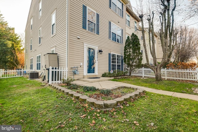 rear view of property with a lawn, central AC, and a patio area