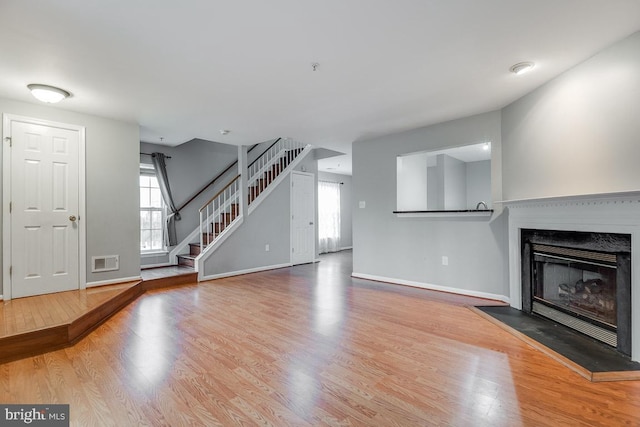 unfurnished living room with a healthy amount of sunlight and hardwood / wood-style floors