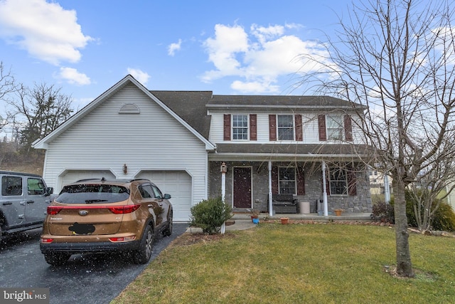 view of front of house featuring a front lawn, a garage, and a porch