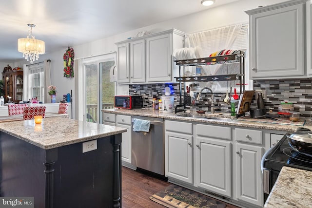 kitchen with stainless steel dishwasher, backsplash, hanging light fixtures, and sink