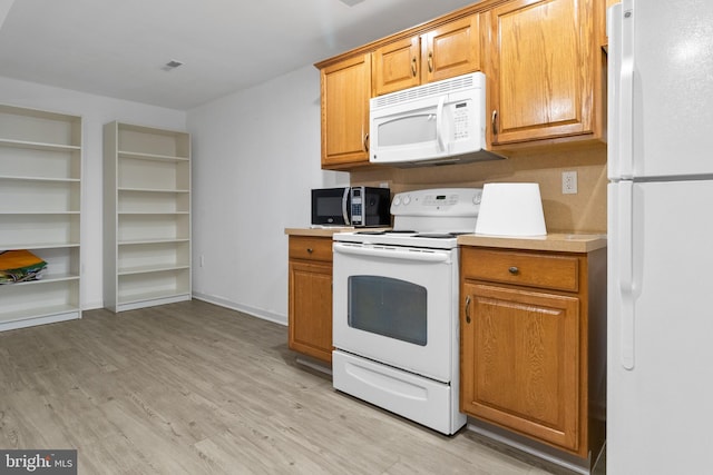 kitchen featuring white appliances and light hardwood / wood-style flooring