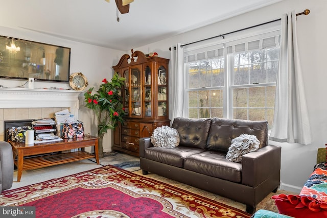 living room with ceiling fan and a fireplace