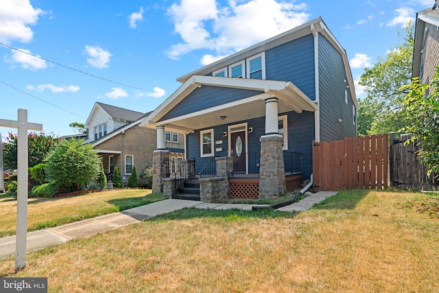 craftsman inspired home featuring covered porch and a front yard