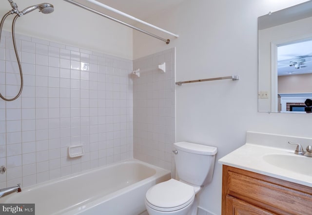 full bathroom with toilet, vanity, and tiled shower / bath combo