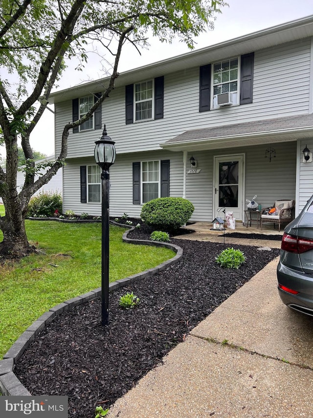 view of front of home featuring cooling unit and a front lawn