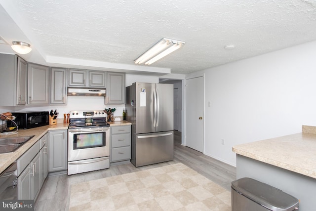 kitchen featuring gray cabinetry, sink, a textured ceiling, and appliances with stainless steel finishes