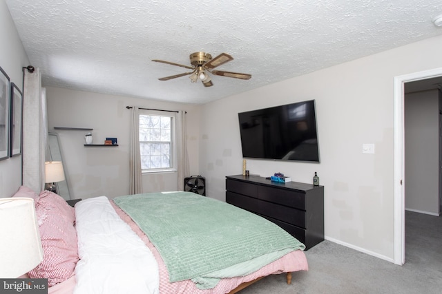 carpeted bedroom with ceiling fan and a textured ceiling