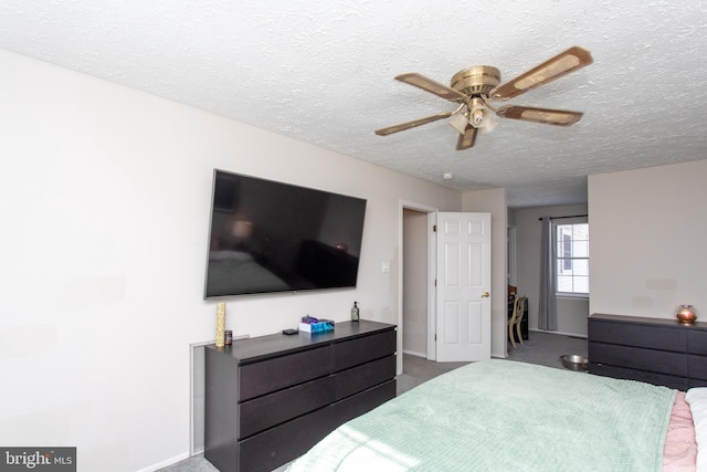 carpeted bedroom featuring ceiling fan and a textured ceiling