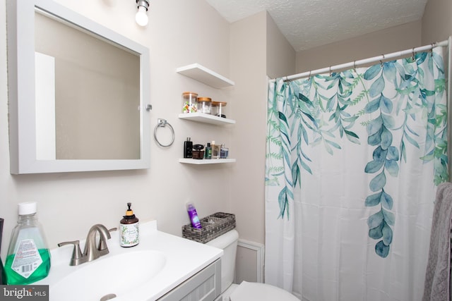 bathroom featuring vanity, a textured ceiling, toilet, and walk in shower