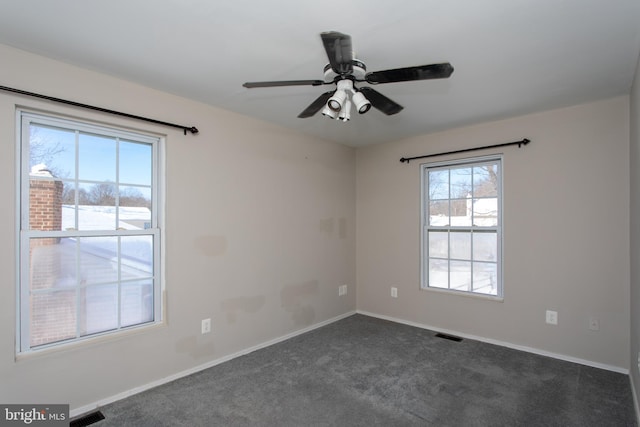 empty room featuring dark colored carpet and ceiling fan