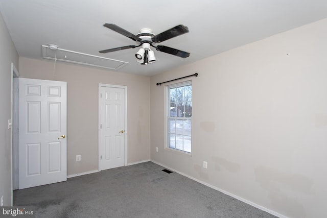 unfurnished bedroom with ceiling fan and dark carpet