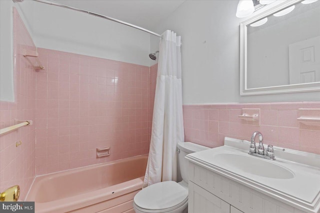 full bathroom with vanity, toilet, tile walls, and shower / tub combo