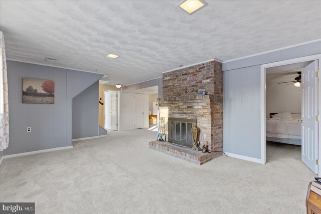 unfurnished living room with a brick fireplace, a textured ceiling, light colored carpet, ceiling fan, and crown molding