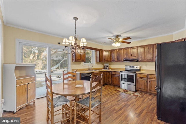 kitchen featuring black appliances, hardwood / wood-style flooring, crown molding, and range hood