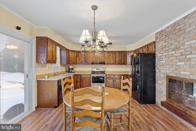 kitchen featuring sink, an inviting chandelier, black appliances, and wood-type flooring