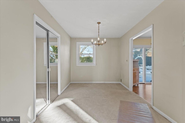 carpeted dining area featuring an inviting chandelier