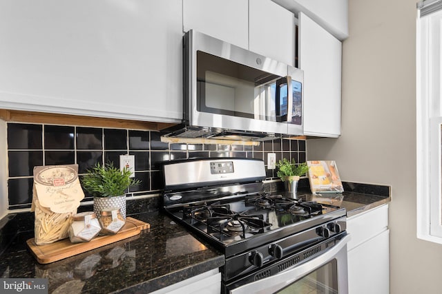 kitchen featuring white cabinets, dark stone counters, and stainless steel appliances