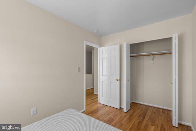 bedroom featuring hardwood / wood-style floors and a closet