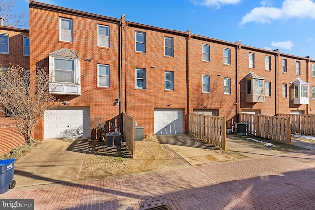 back of property featuring a garage and central air condition unit