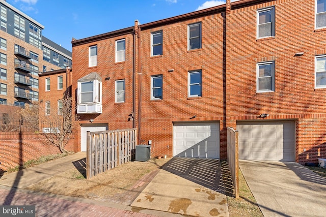 back of property featuring a garage and central AC unit