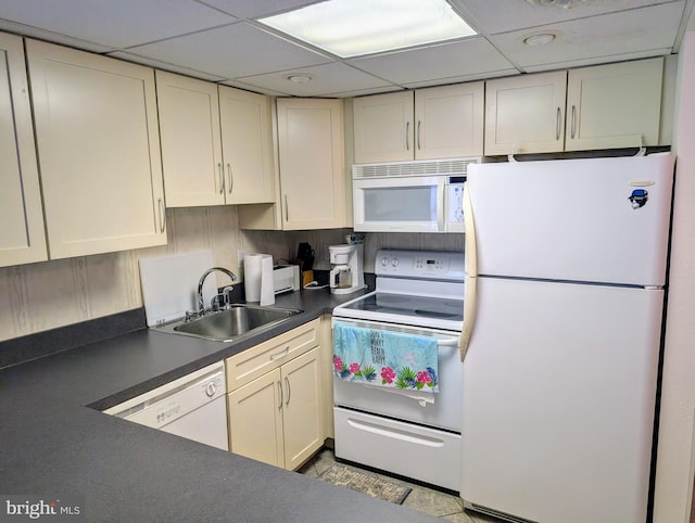 kitchen with cream cabinets, white appliances, a drop ceiling, and sink