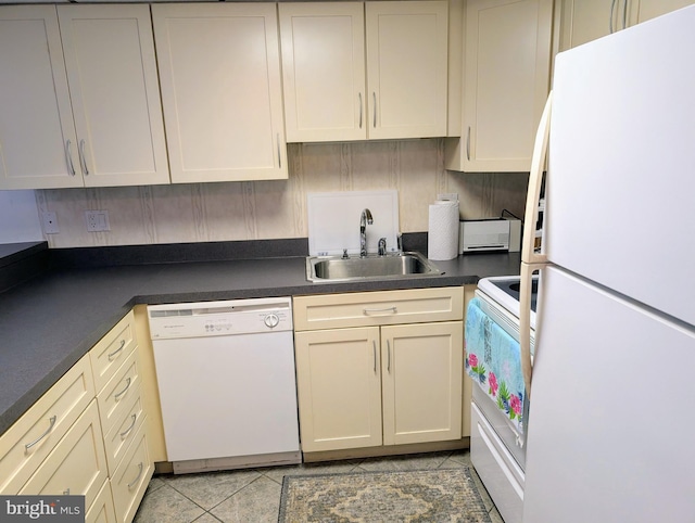 kitchen with cream cabinetry, white appliances, sink, and light tile patterned floors